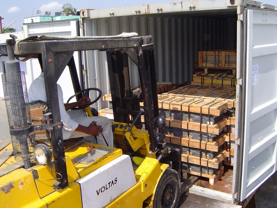 Forklift stuffing wooden crates into a container